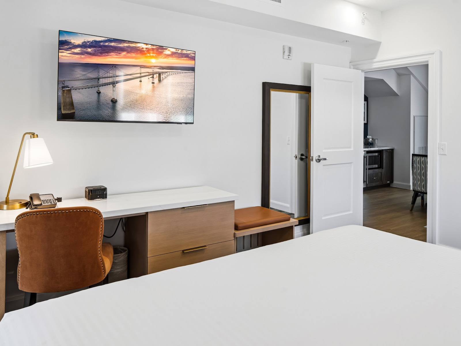 Anchor Suite king bedroom at Wilson’s Cove with desk, television and access to the separate living area.