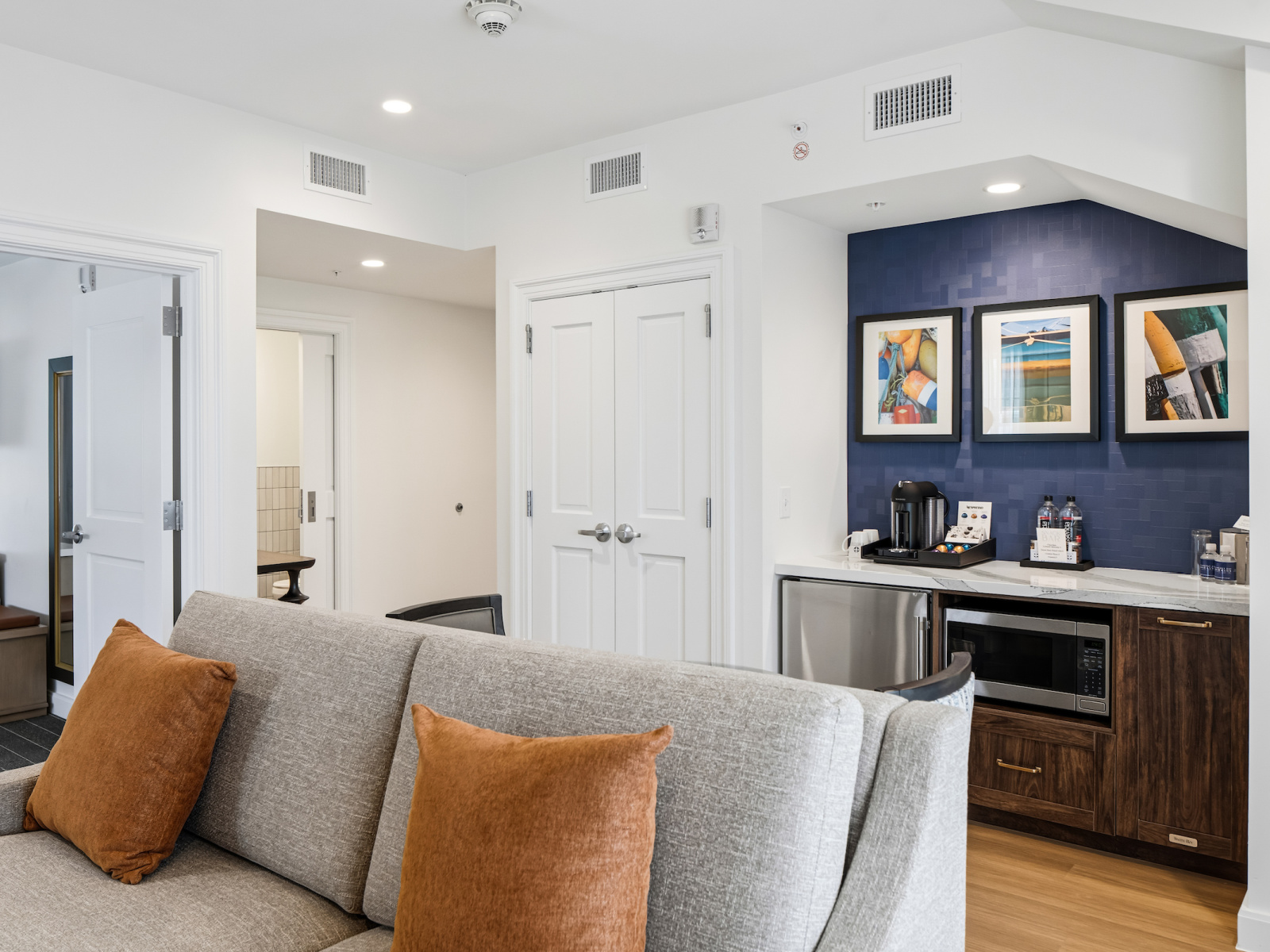 Wilson’s Cove Anchor Suite king bedroom with coastal blue accents and adjoining living area.