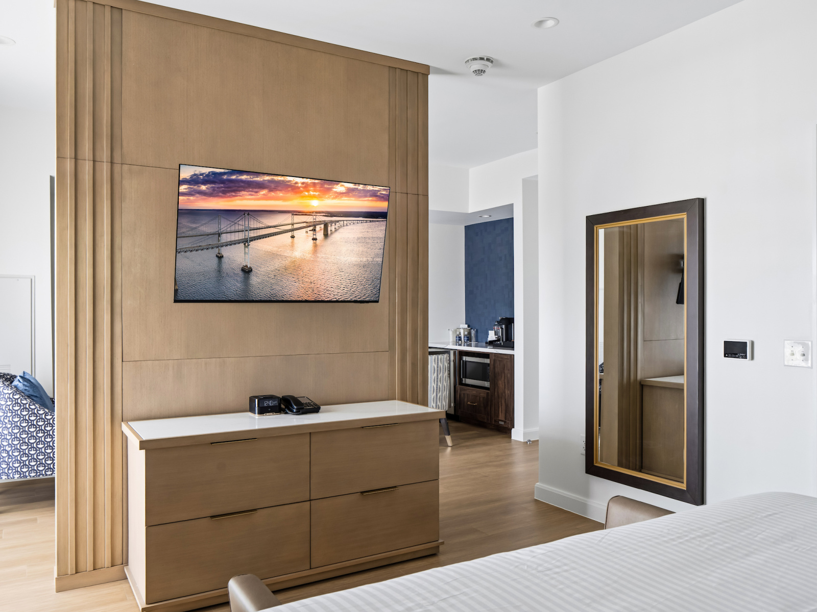 Beacon Suite king bedroom at Wilson’s Cove with television, dresser and adjoining living area.