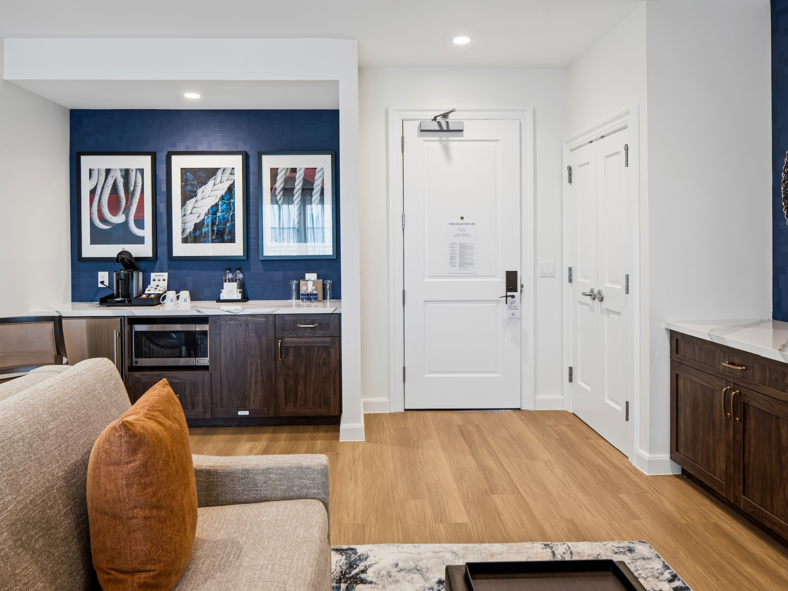 Wilson’s Cove Harbor Suite living area with wet bar, coffee station and coastal artwork