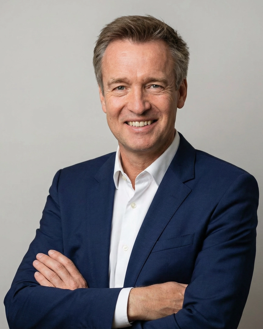 Dr. Andreas Hartung, unabhängiger Gesundheitsberater bei H2A Hartung Healthcare Advisory lächelt mit verschränkten Armen in die Kamera vor einem weißen Hintergrund.