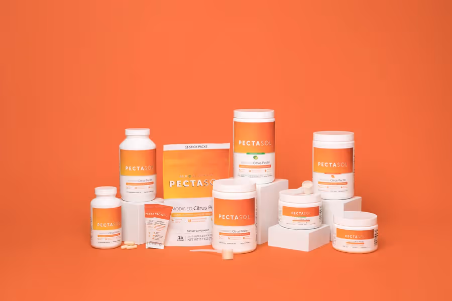 Collection of Pectasol dietary supplement products in orange and white packaging arranged on white blocks against an orange background.