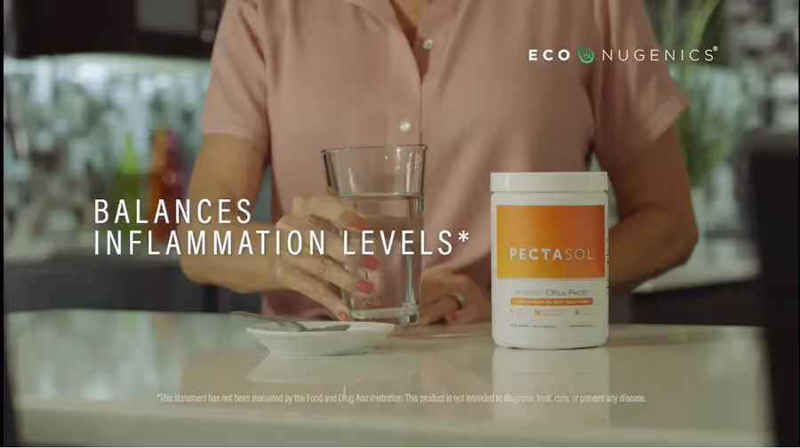 Person in a pink shirt holding a glass of water next to a container of PECTASOL supplement labeled to balance inflammation levels.
