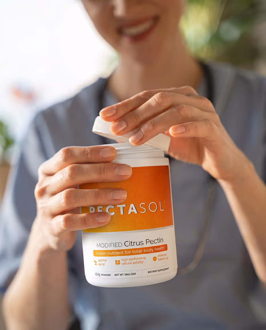 Woman opening a container of Pectasol Modified Citrus Pectin dietary supplement powder.