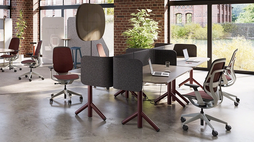 Height-adjustable workstation system with ergonomic chairs and collaborative desk layout in a modern office space