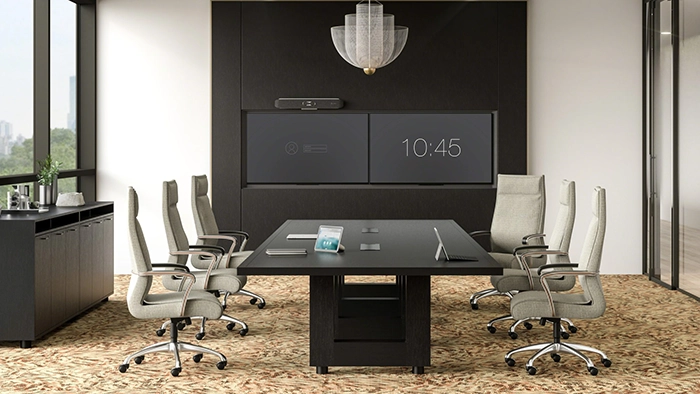 Conference room with executive office chairs around a meeting table and integrated screens for presentations