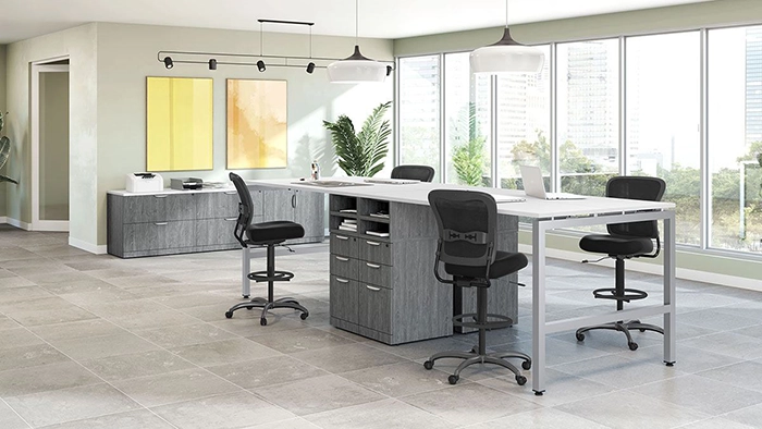 Standing-height office tables with task chairs and storage units in a modern collaborative workspace