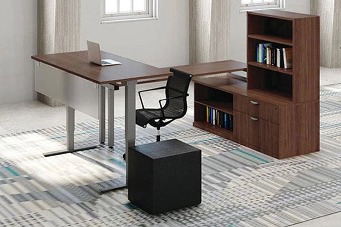 Office desk with open shelving and storage cabinet for books and supplies in a clean workspace environment