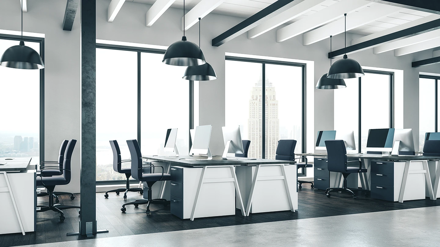 Modern commercial office with benching workstations, ergonomic task chairs, pendant lighting, and floor-to-ceiling windows