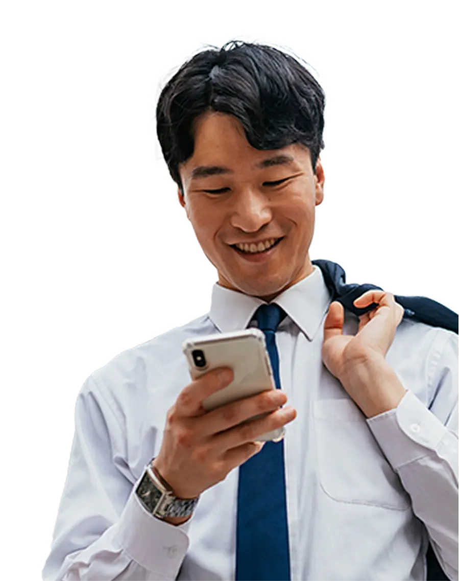 Smiling man in white shirt and blue tie holding jacket and looking at smartphone.