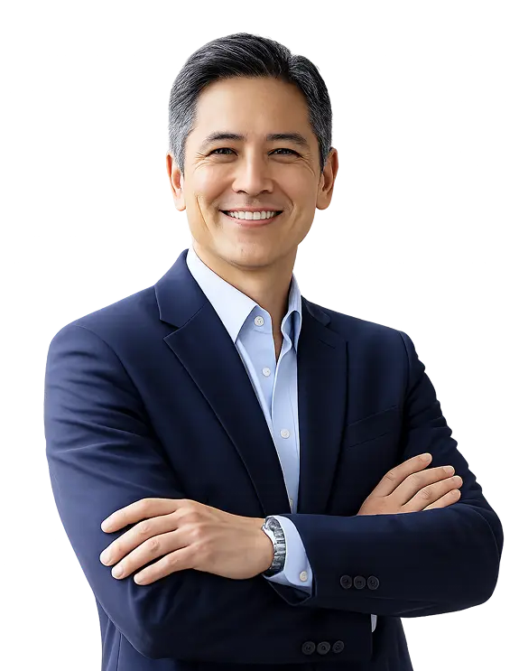Smiling man in a dark blue suit with arms crossed, looking confidently at the camera.