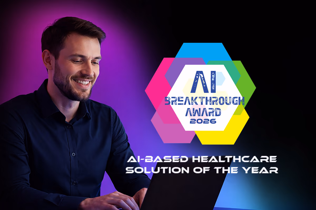 Man smiling, holding laptop, beside AI Breakthrough Award for AI-based Healthcare Solution of the Year.