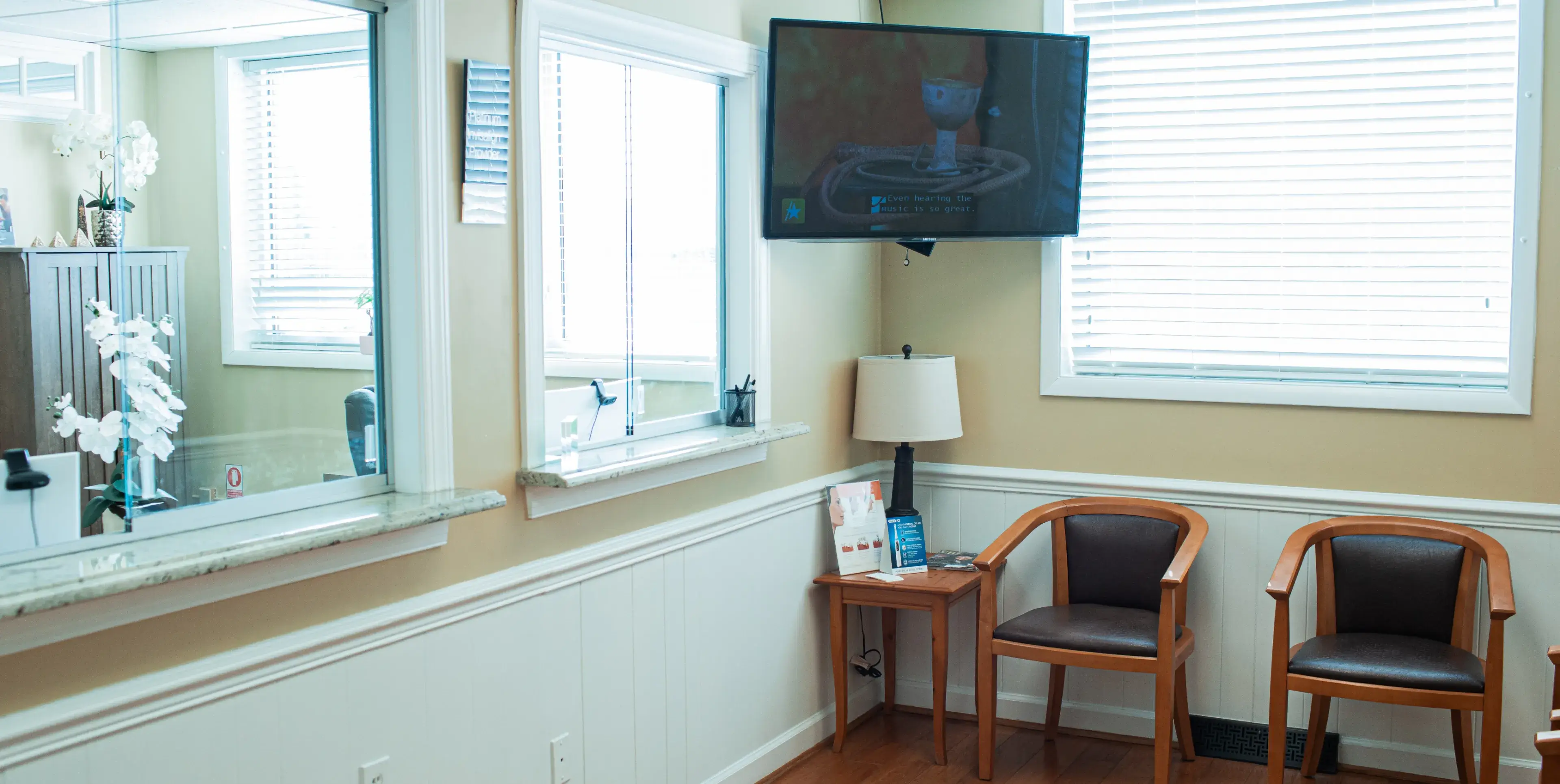 A room with two chairs and a flat screen tv.