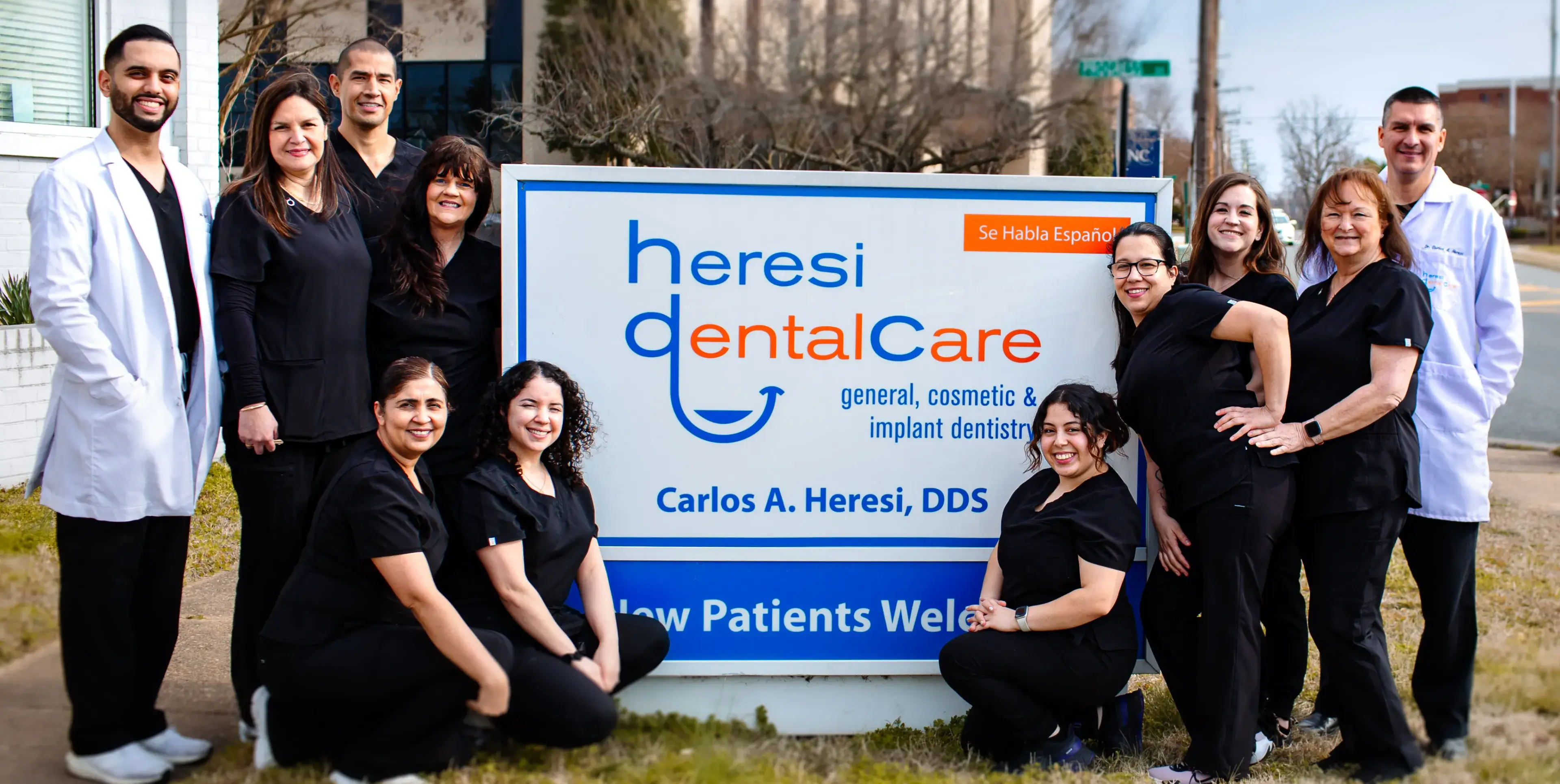 A group of people standing in front of a sign.