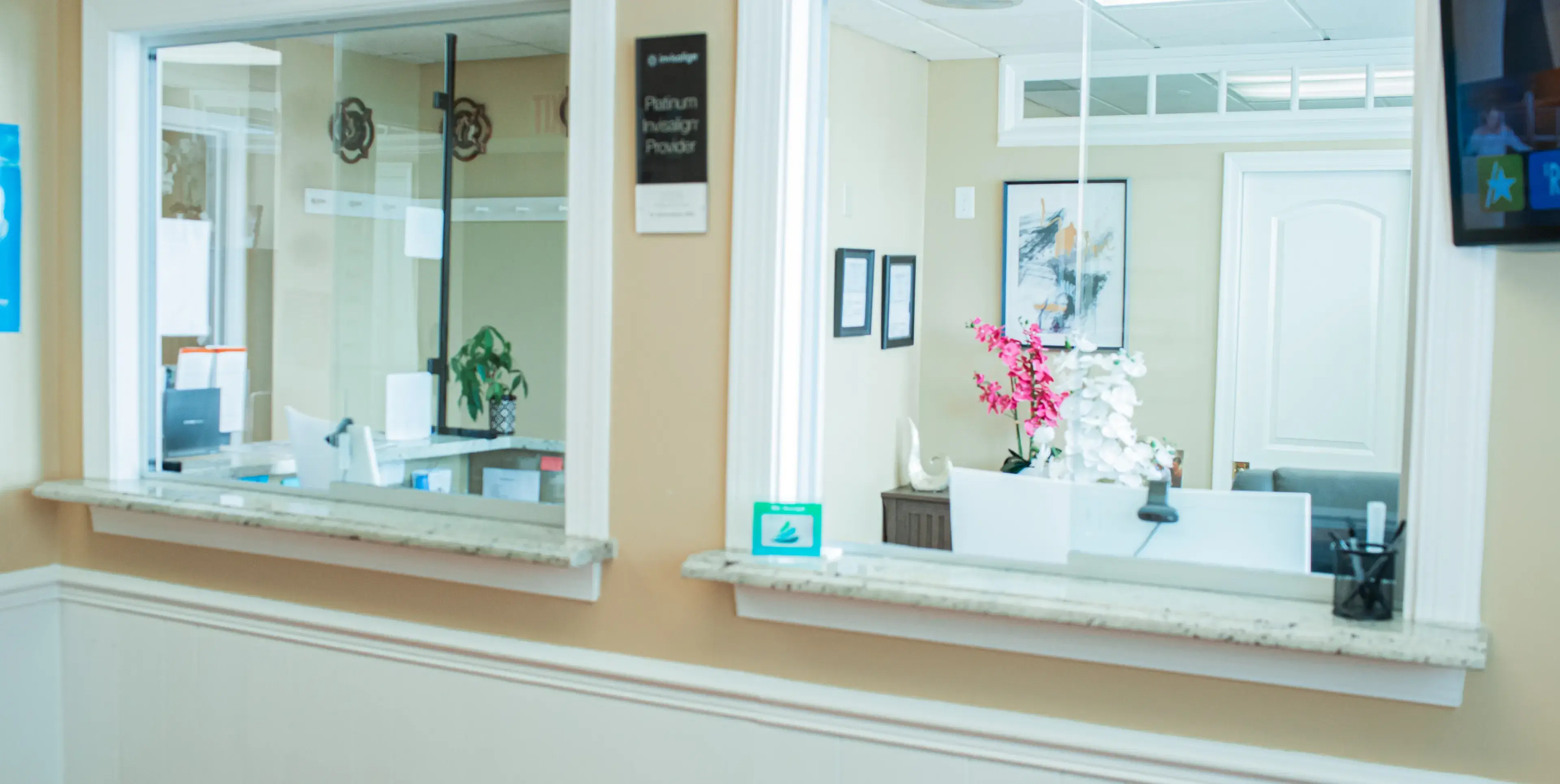 A bathroom mirror with a vase of flowers on it.