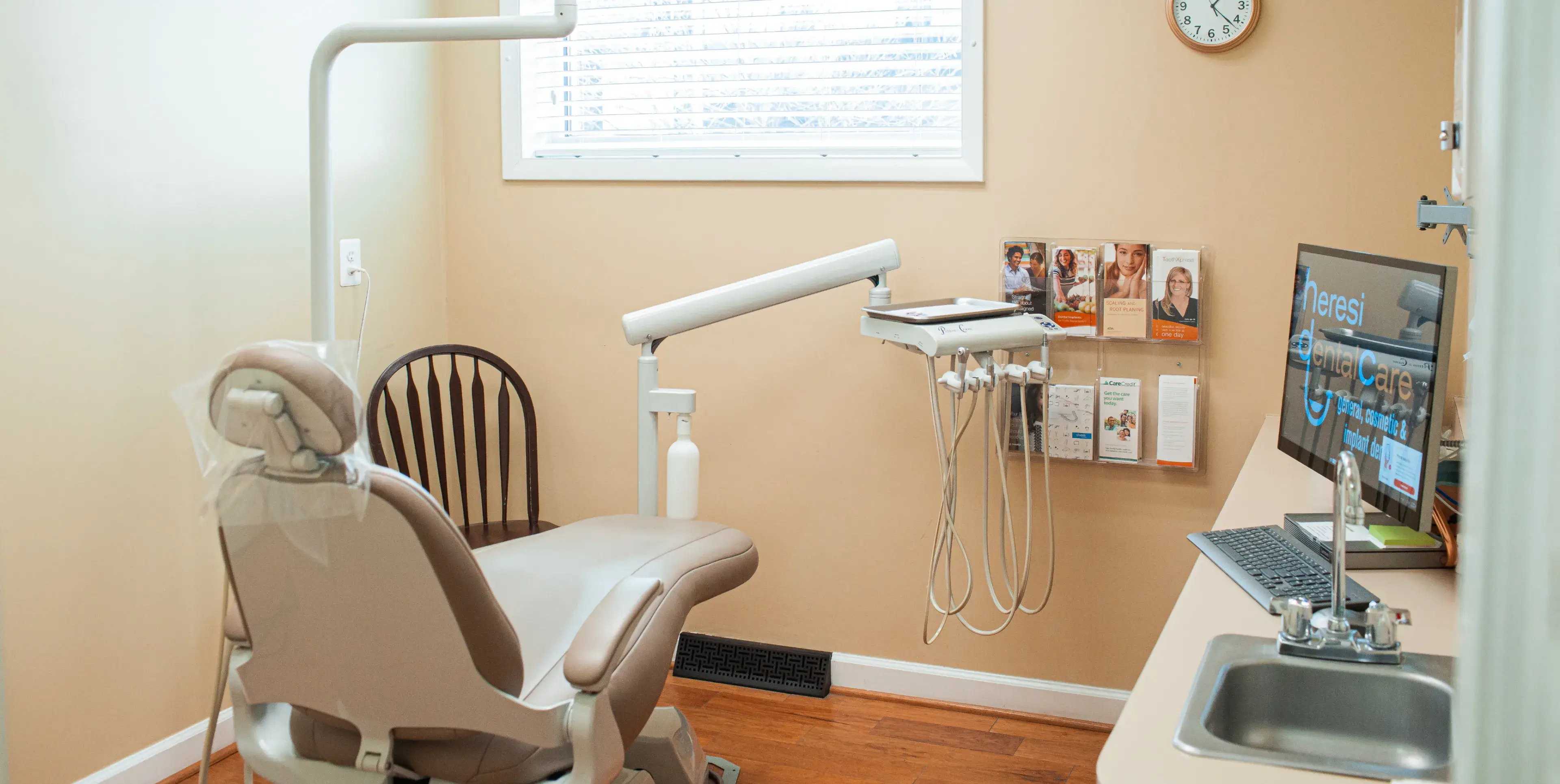 A dental office with a computer and a chair.