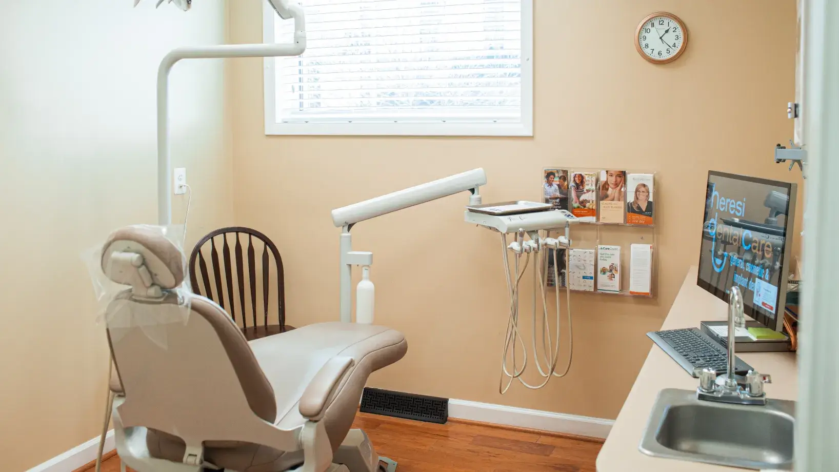 A dental office with a laptop and monitor.