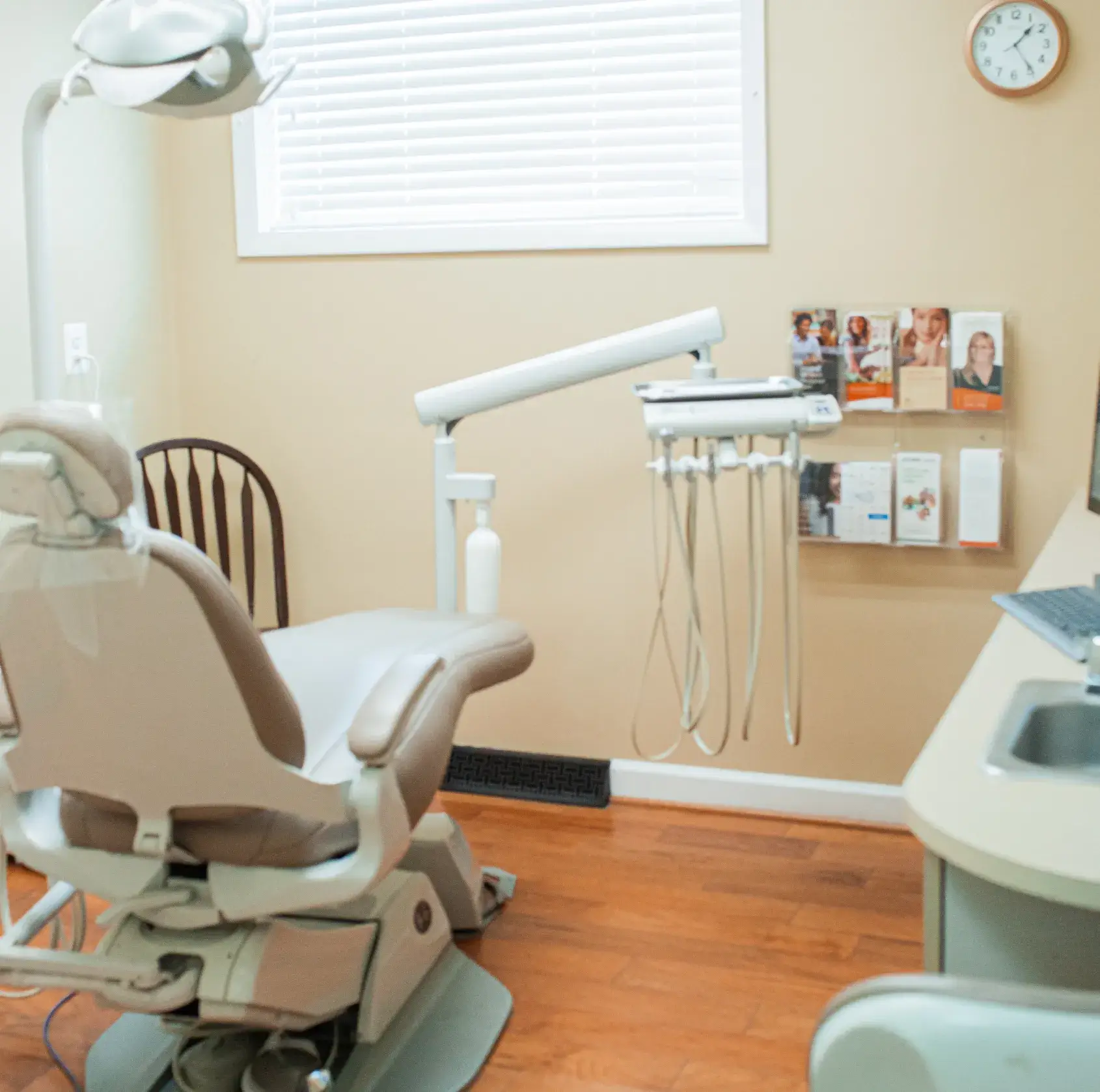 A dentist's office with a laptop on the desk.