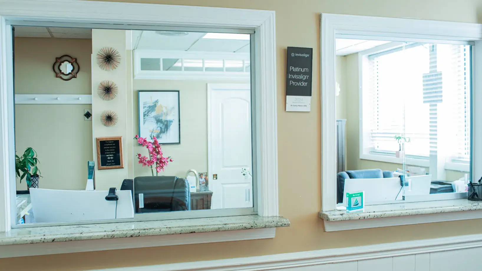 A mirror reflecting a hair dresser and a flower vase.