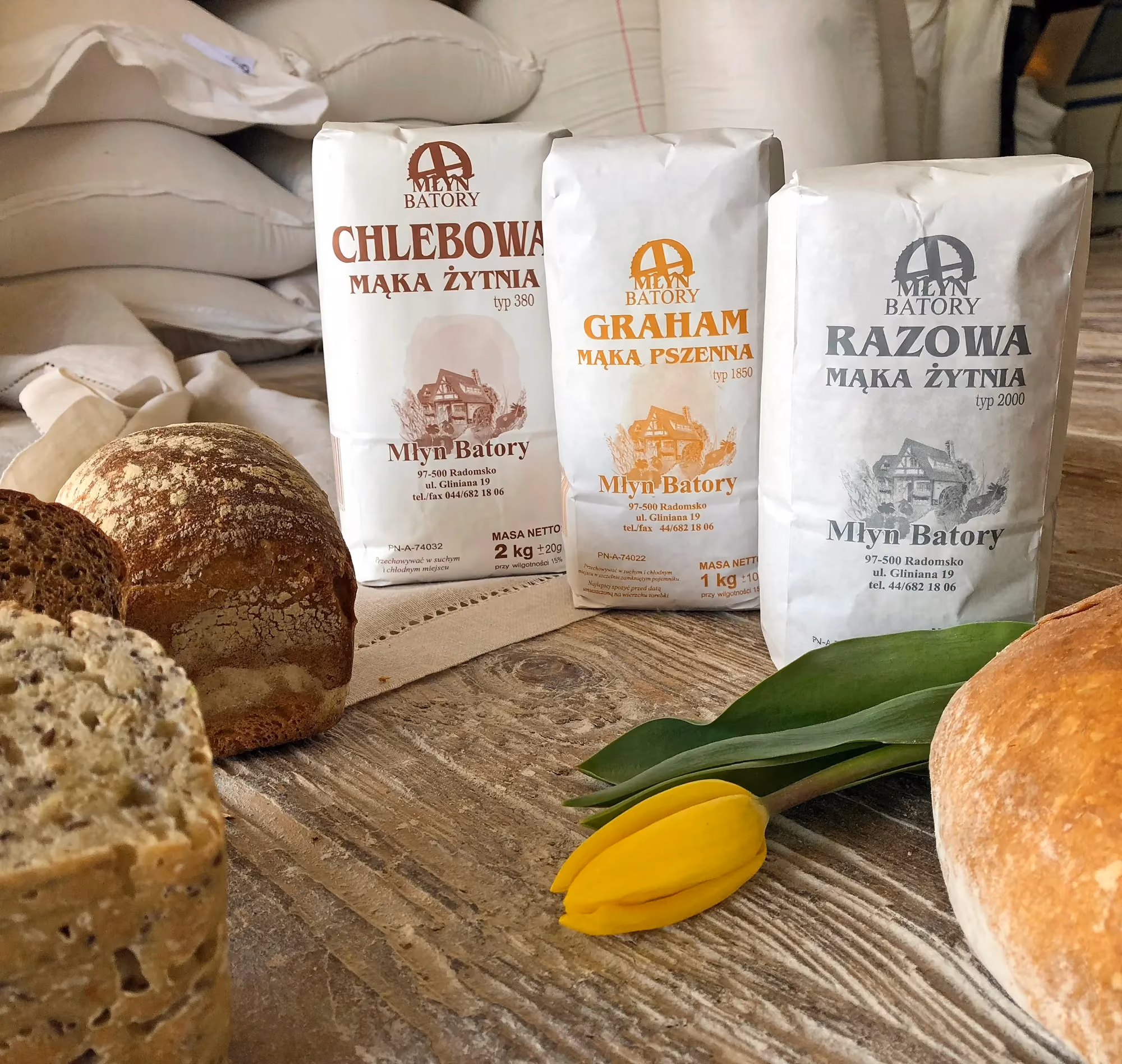 Świeżo wypieczony chleb oraz opakowania mąki marki Młyn Batory