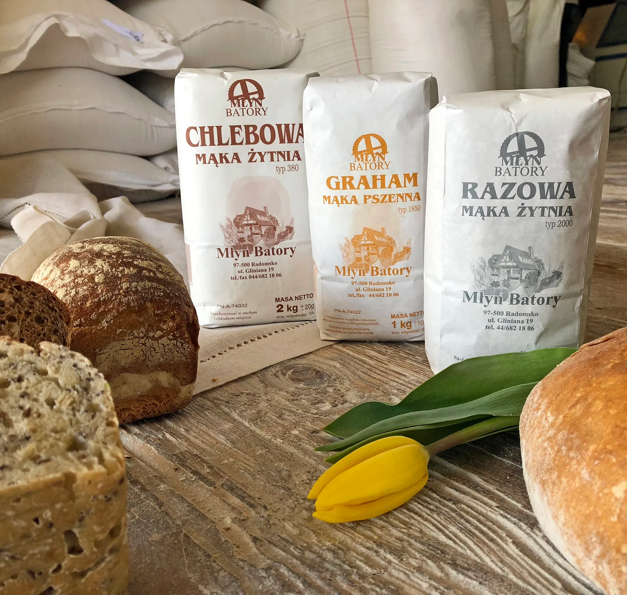 Świeżo wypieczony chleb oraz opakowania mąki marki Młyn Batory