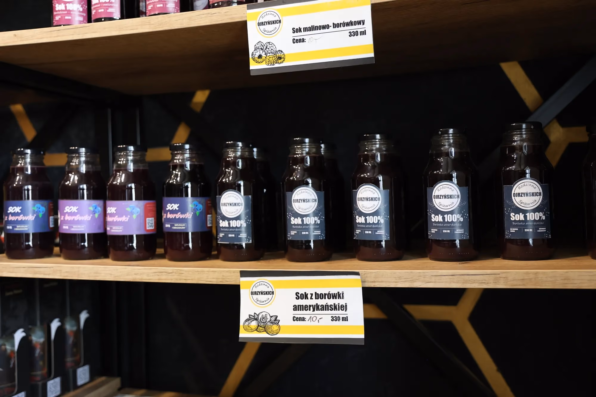 Wnętrze sklepu z miodami, widoczne regały z produktami i lada.
