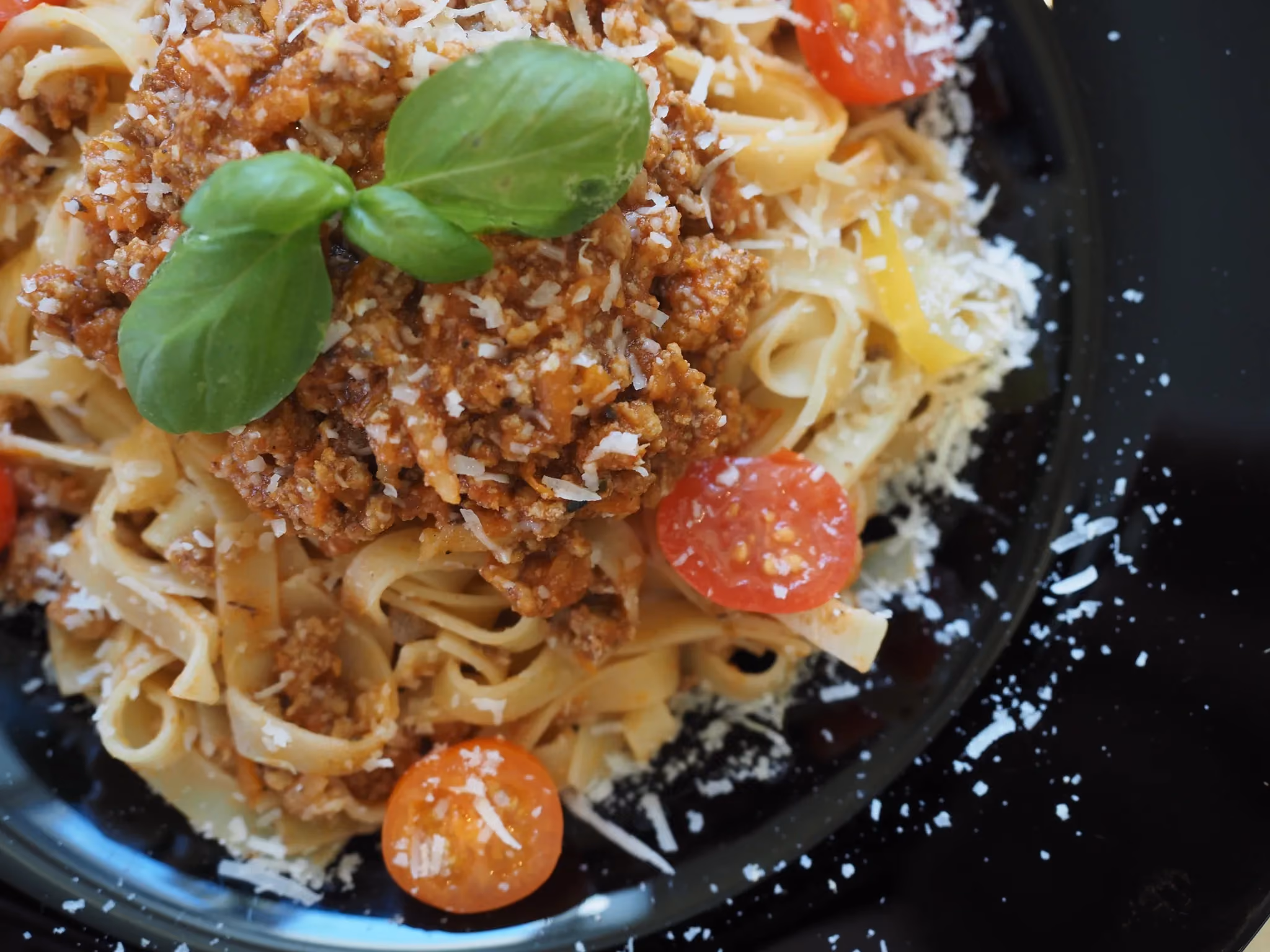 Makaron tagliatelle bolognese z parmezanem i pomidorkami koktajlowymi