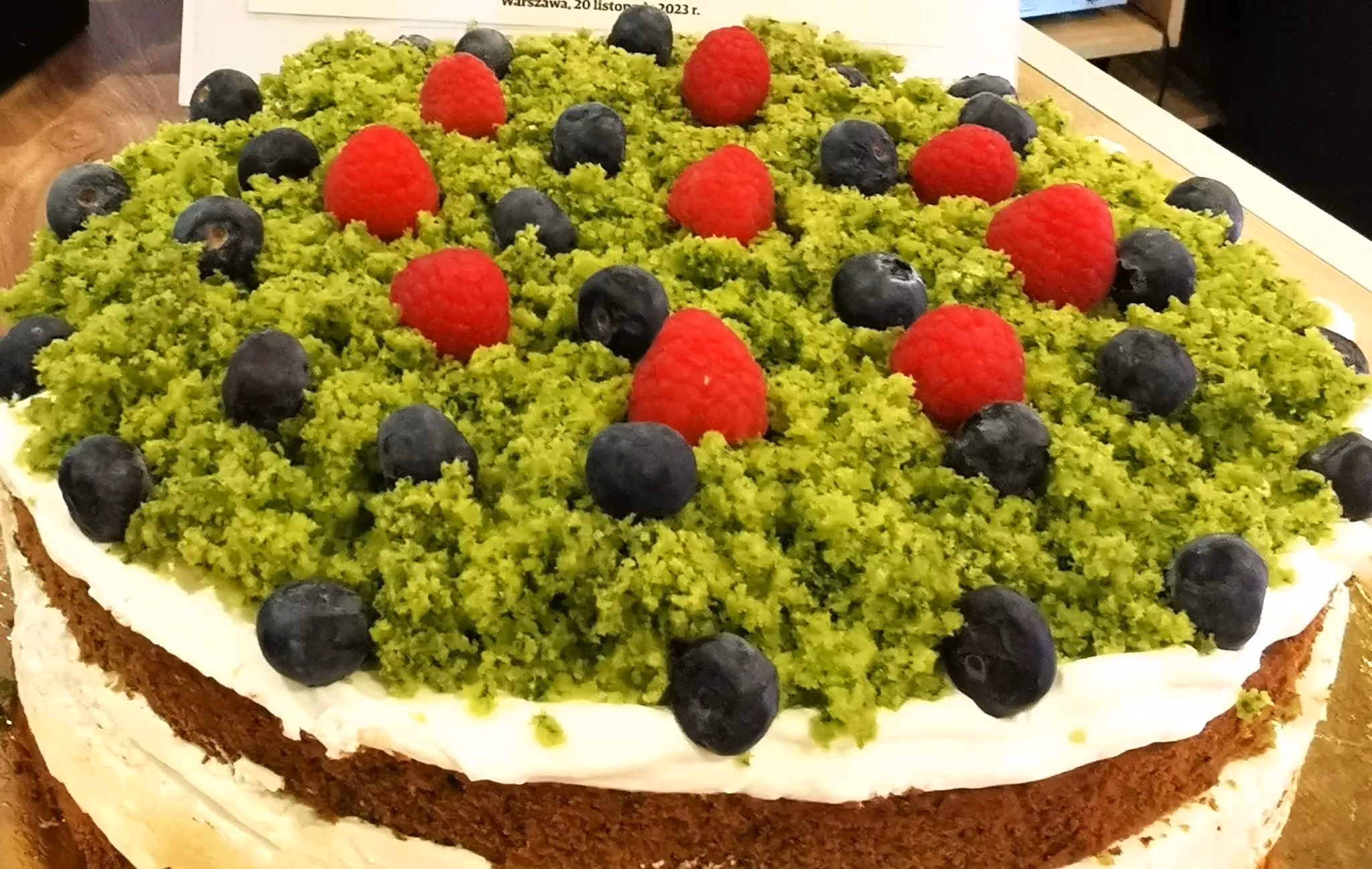 Tort pistacjowy z malinami i borówkami serwowany w kawiarni Bazylia