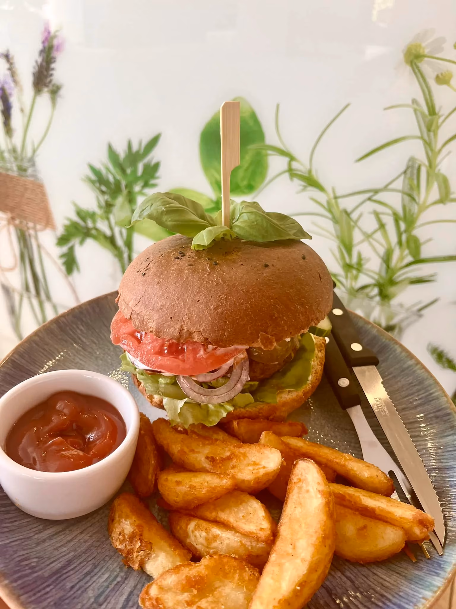 Burger wołowy z frytkami i sosem podawany w restauracji Bazylia