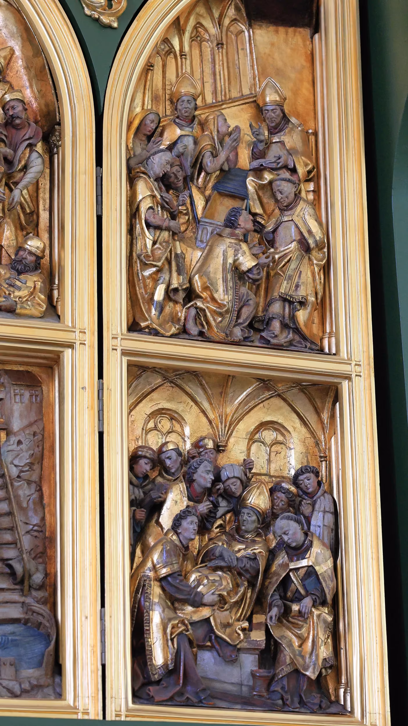 Fragment gotyckiego ołtarza z rzeźbioną sceną religijną.