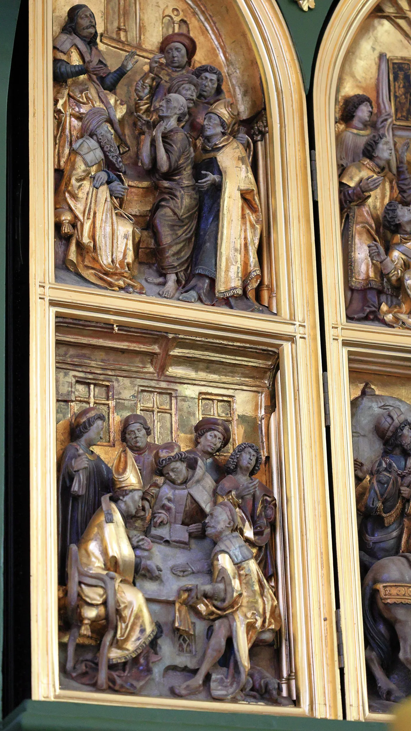 Fragment gotyckiego ołtarza z rzeźbioną sceną religijną.