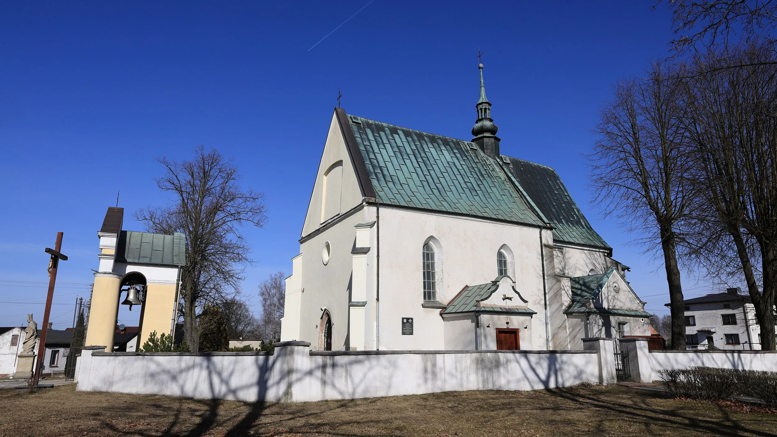 Kościół pw. św. Marcina w Kodrębie widziany z boku. Widoczna dzwonnica-brama, mur otaczający teren oraz dach pokryty blachą