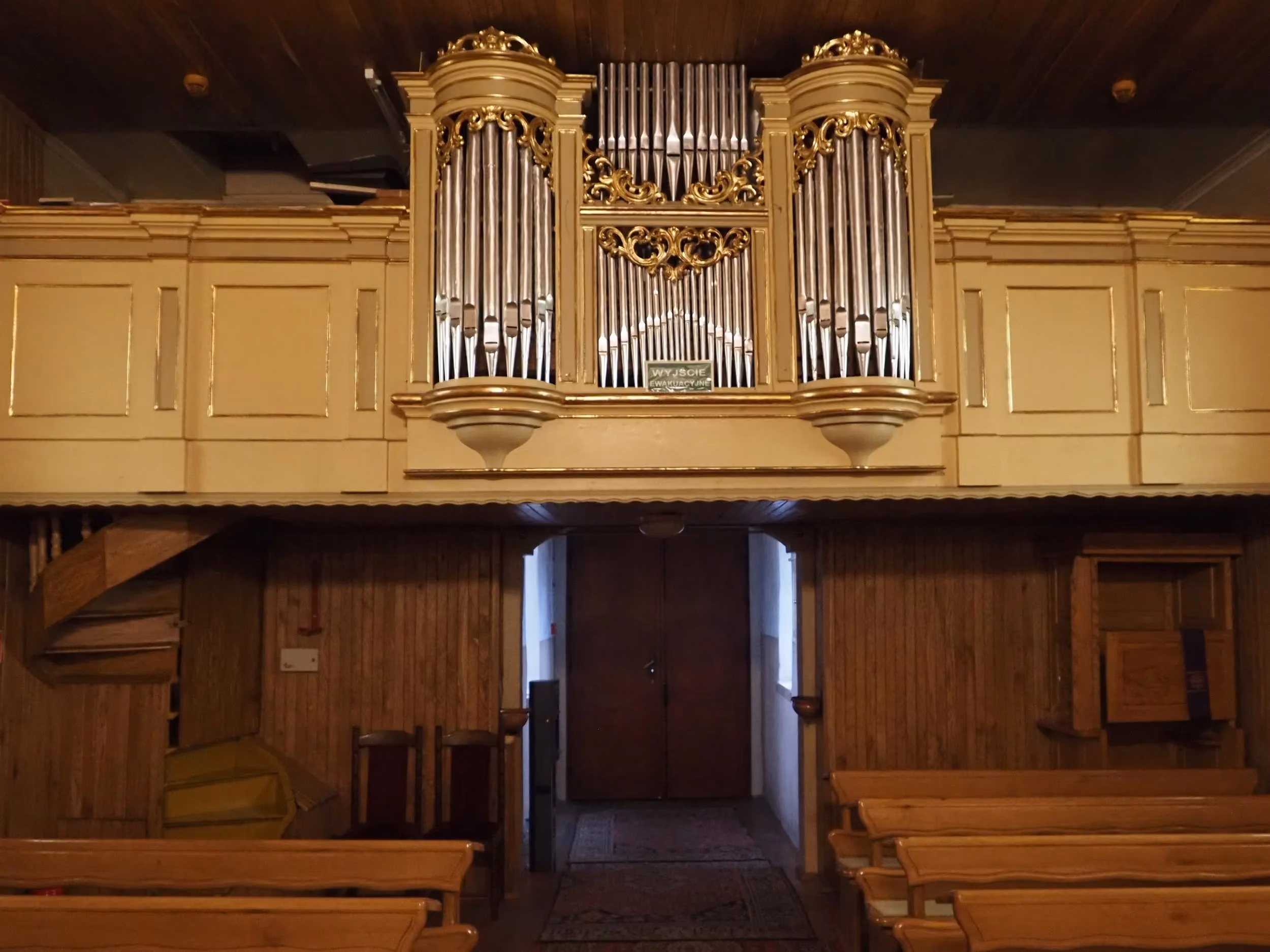 Chór muzyczny z organami we wnętrzu kościoła w Bugaju Zakrzewskim. Pod chórem widoczne wejście do świątyni.