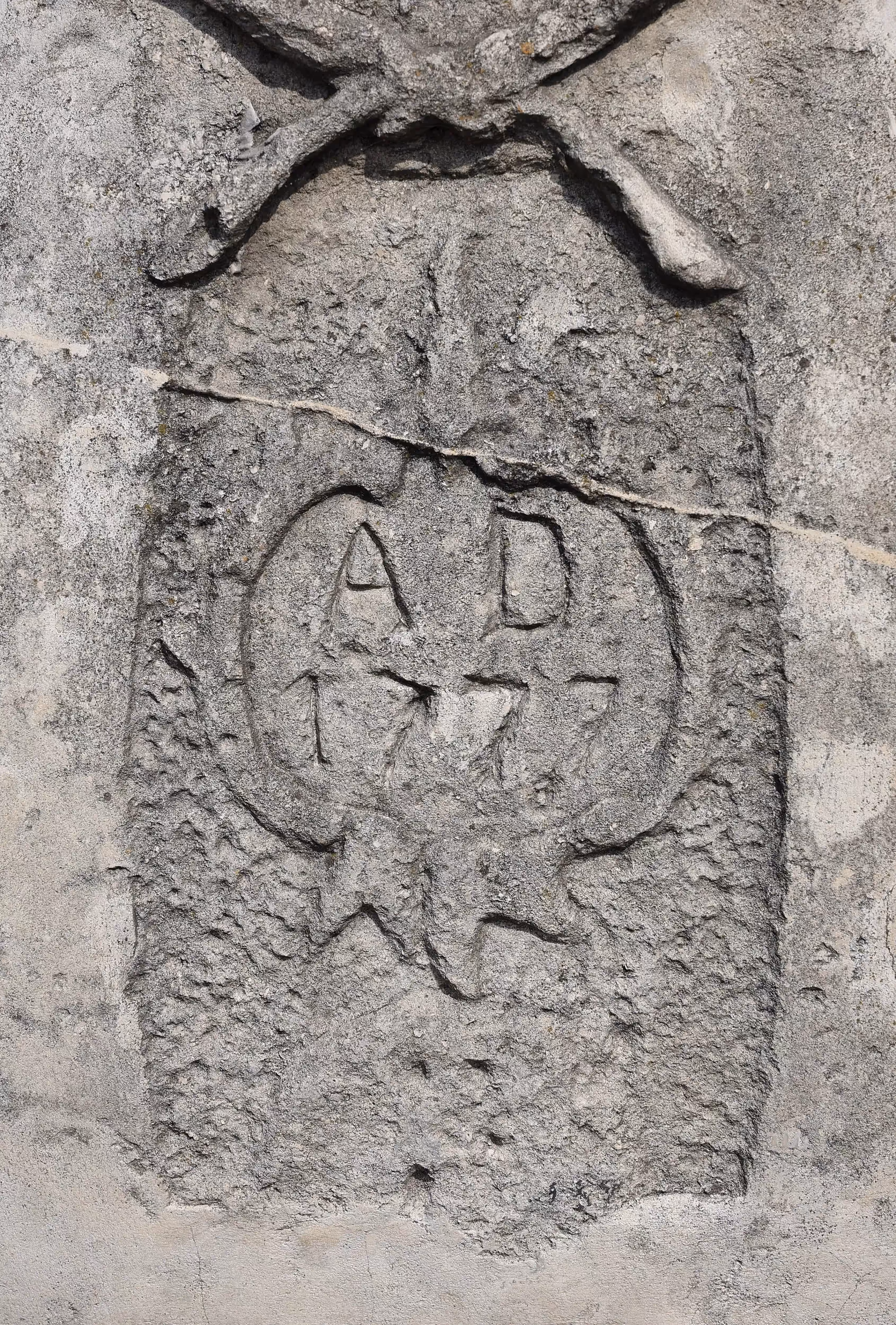 Fragment postumentu figury św. Jana Nepomucena z częściowo zachowaną datą „AD 1777” i śladami wieloletniego użytkowania.