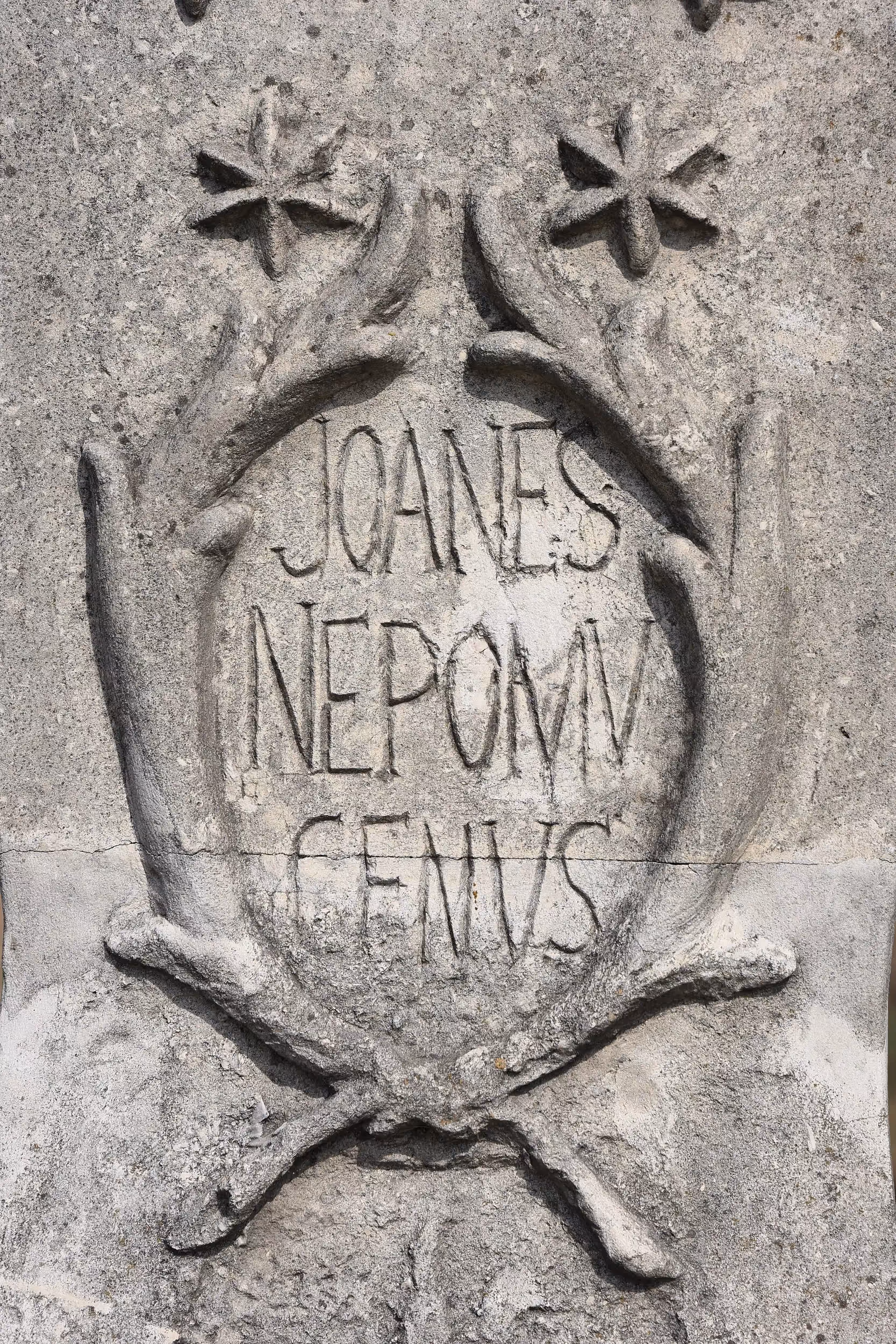 Detal inskrypcji „Joanes Nepomucenus” wykutej w kamiennym postumencie figury świętego w Przerębie.