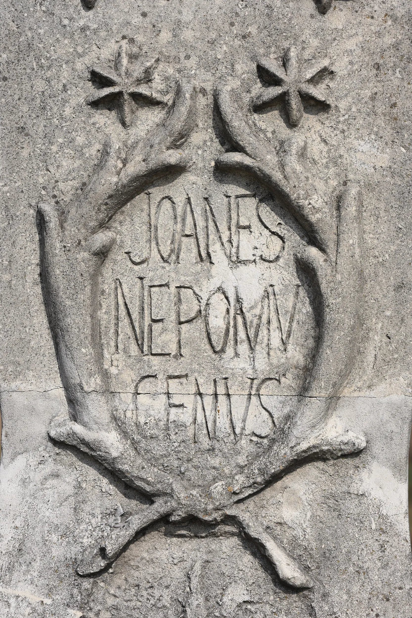 Detal inskrypcji „Joanes Nepomucenus” wykutej w kamiennym postumencie figury świętego w Przerębie.