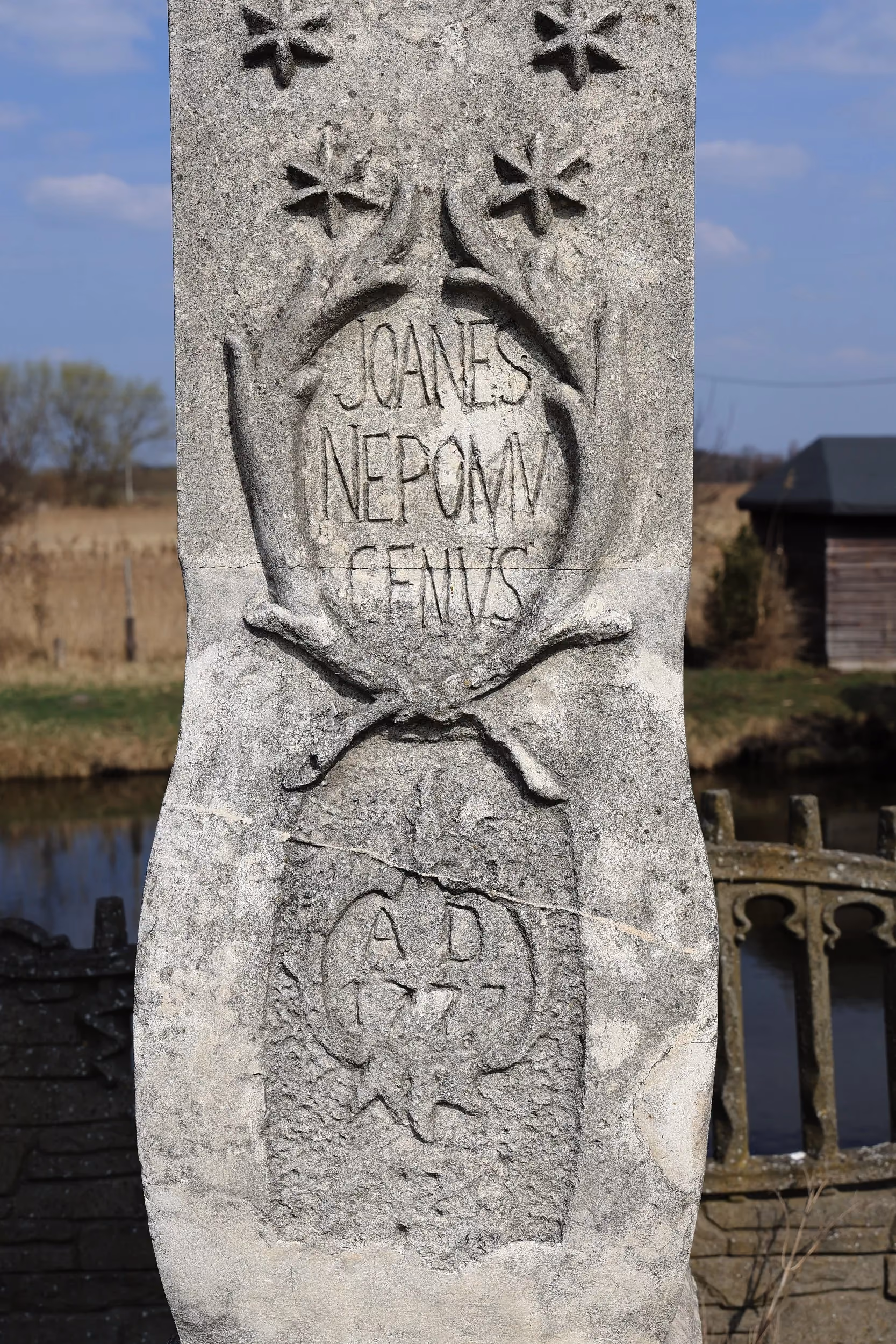 Zbliżenie na postument figury św. Jana Nepomucena z wyrytym napisem „Joanes Nepomucenus” oraz datą fundacji.