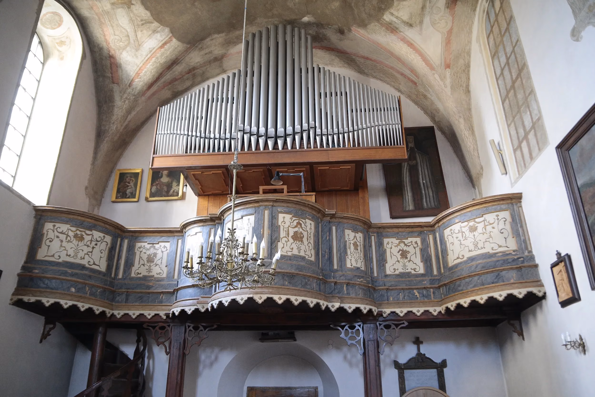 Chór muzyczny i organy w kościele w Strzałkowie. Widoczne dekorowane balustrady oraz sklepienie z zachowanymi polichromiami.