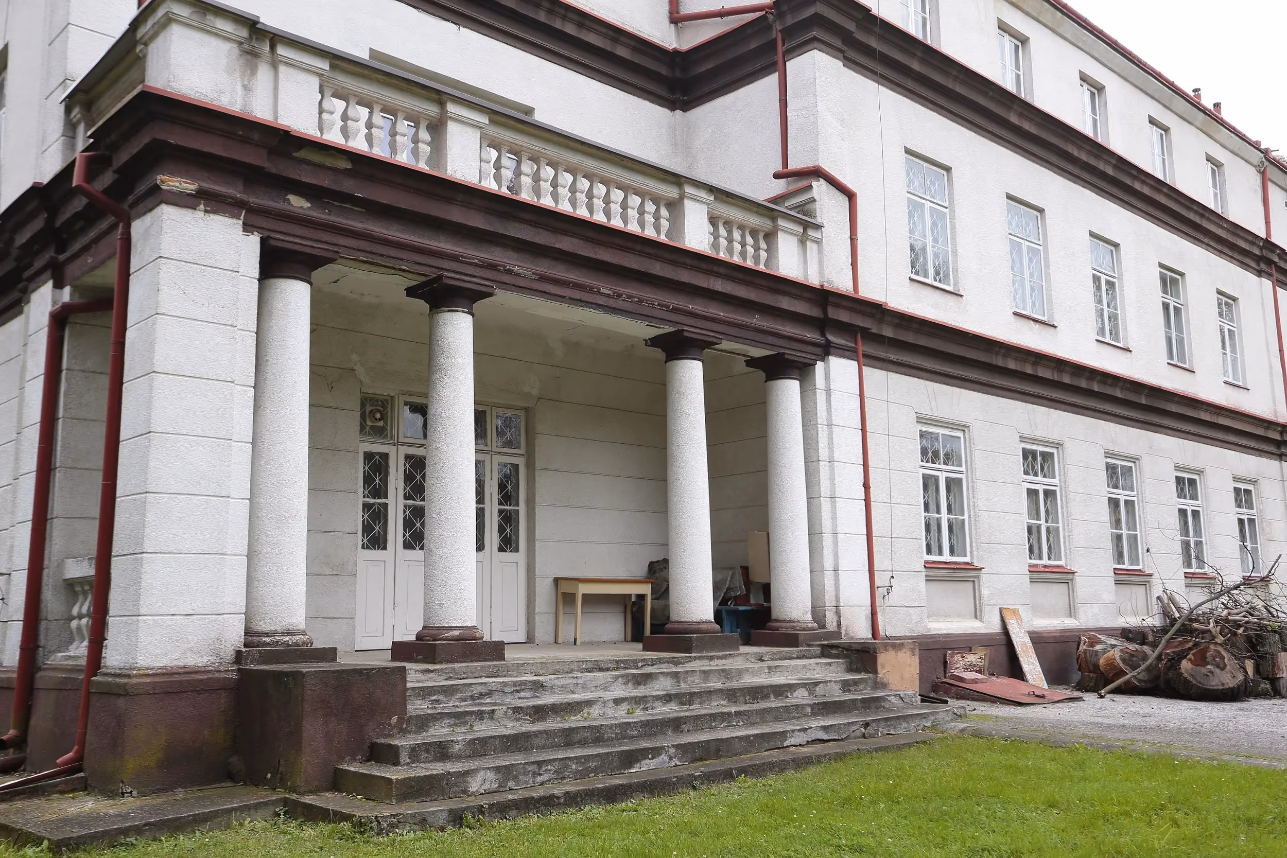 Pałac w Strzałkowie z reprezentacyjnym wejściem. Widoczny portyk wsparty na kolumnach, schody oraz elewacja historycznego budynku.