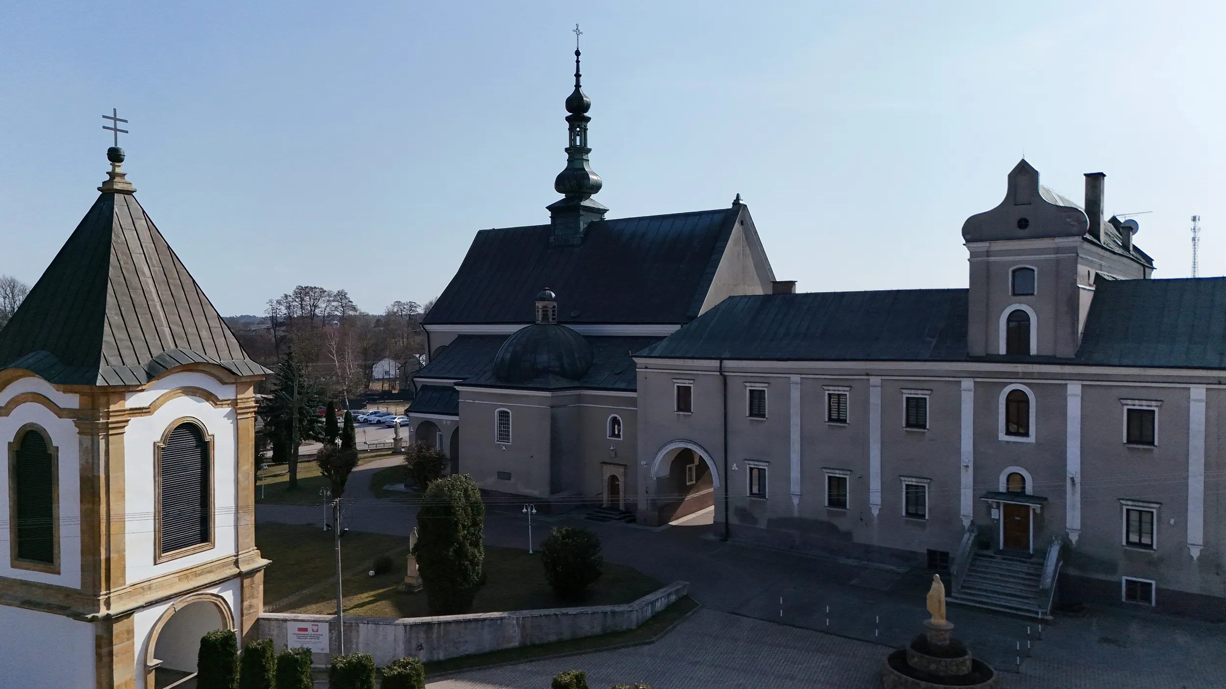 Kościół parafialny i wolnostojąca dzwonnica w Wielgomłynach. Na pierwszym planie widoczny jest ogrodzony dziedziniec świątyni.
