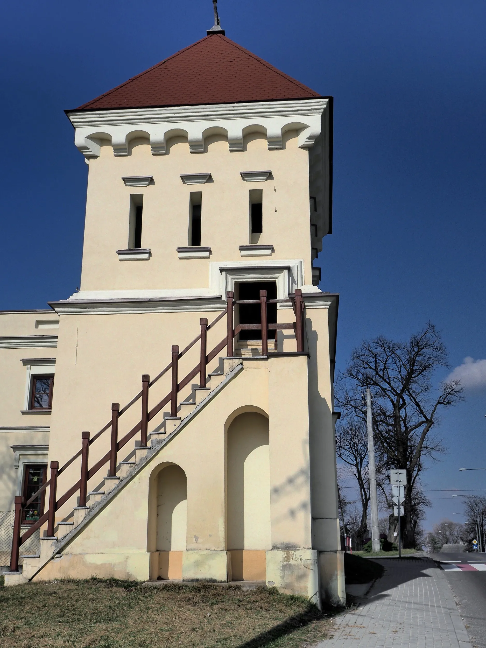 Wieża bramna zespołu pałacowego w Maluszynie. Budowla z arkadowym przejazdem, zewnętrznymi schodami i czterospadowym dachem.