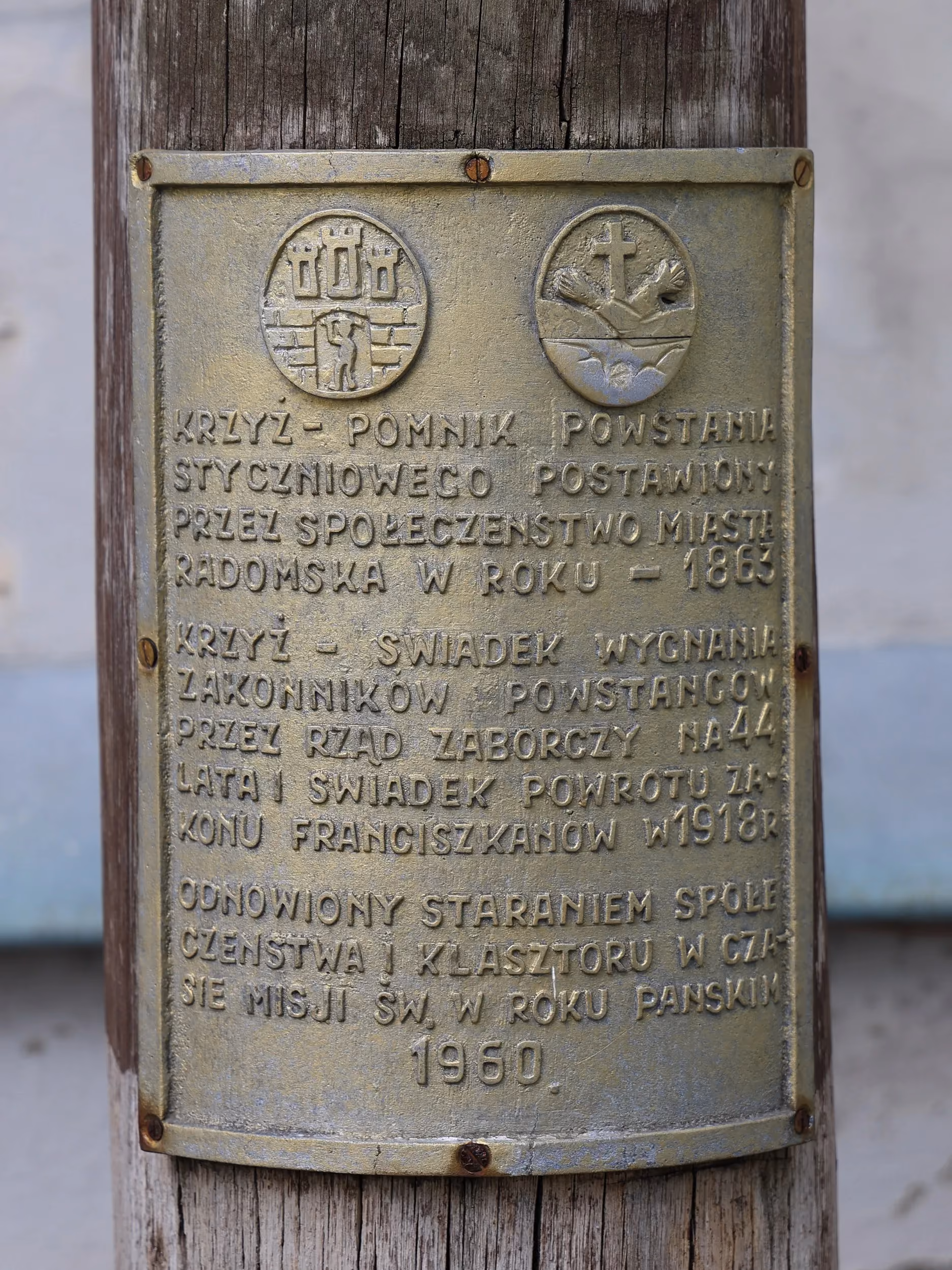 Tablica na krzyżu upamiętniająca Powstanie Styczniowe oraz losy franciszkanów związanych z klasztorem w Radomsku.