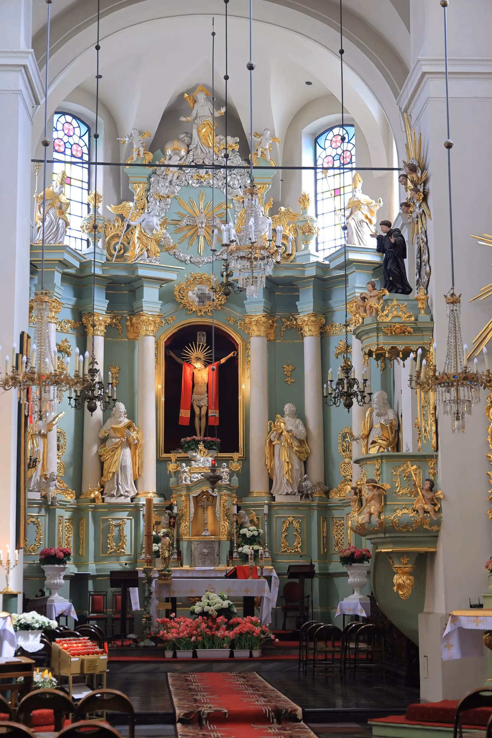 Bogato zdobiony barokowy ołtarz główny w kościele przy klasztorze franciszkanów w Radomsku z figurami świętych i krucyfiksem.