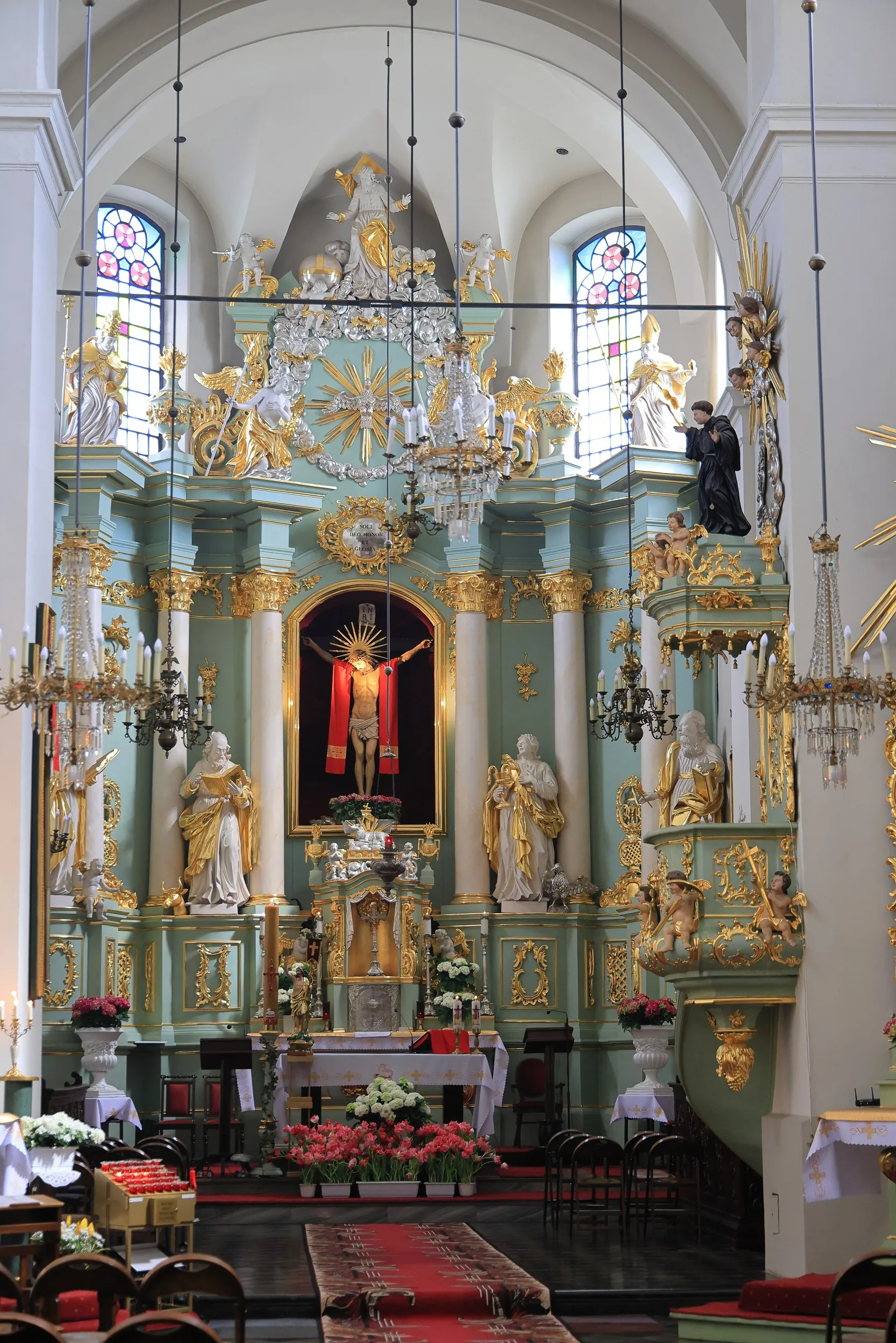 Bogato zdobiony barokowy ołtarz główny w kościele przy klasztorze franciszkanów w Radomsku z figurami świętych i krucyfiksem.