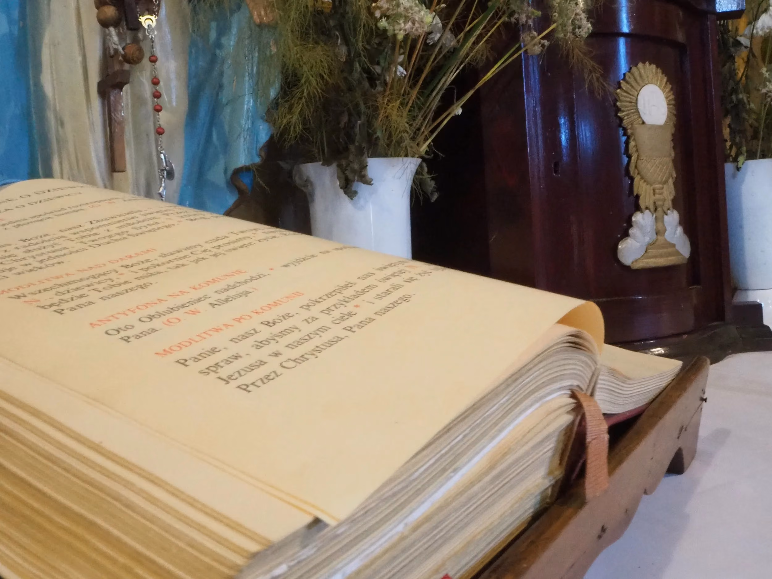 Otwarta księga liturgiczna na ołtarzu kaplicy św. Rozalii w Radomsku. W tle widoczne elementy wyposażenia i dekoracje kwiatowe.