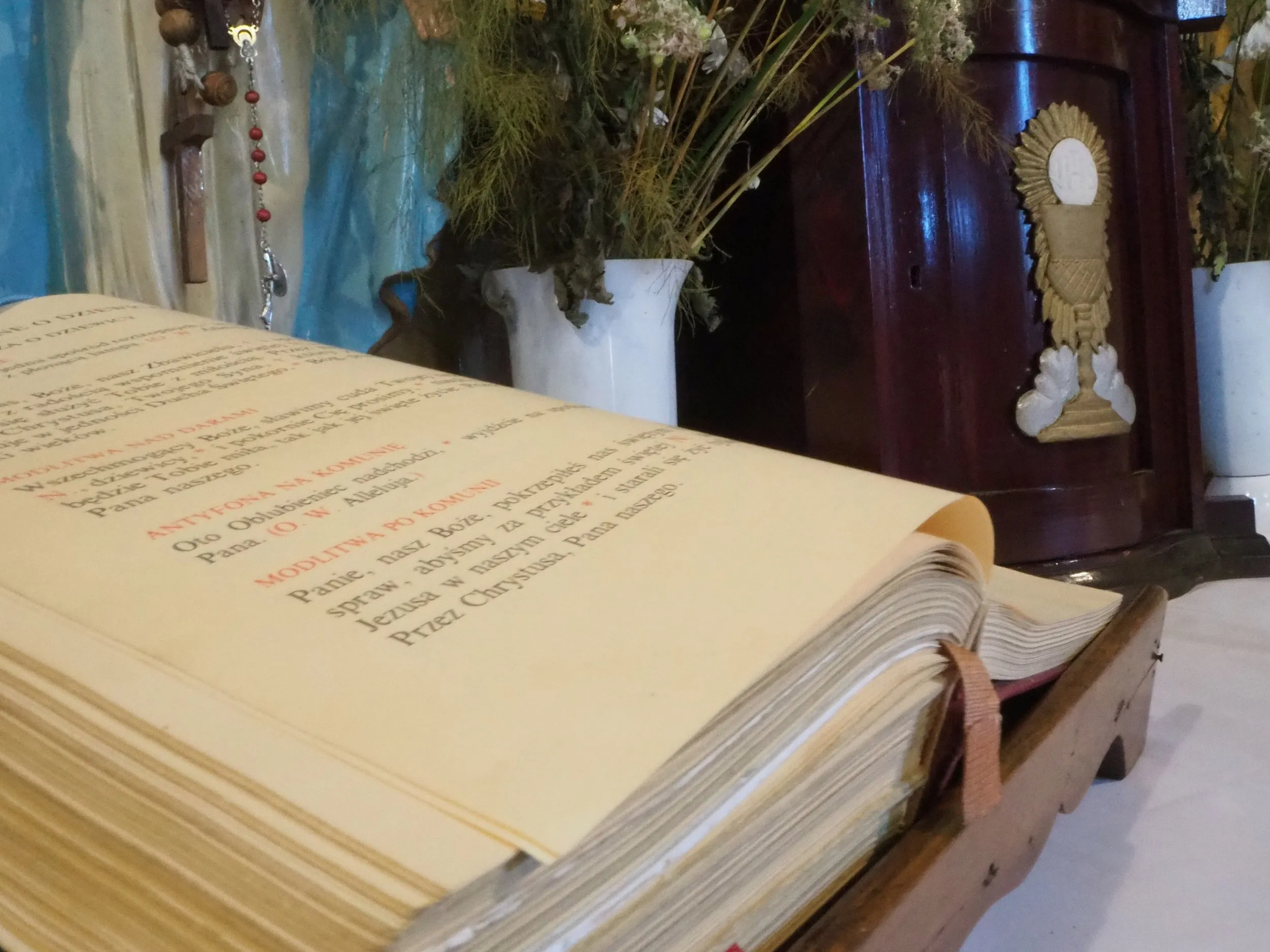 Otwarta księga liturgiczna na ołtarzu kaplicy św. Rozalii w Radomsku. W tle widoczne elementy wyposażenia i dekoracje kwiatowe.