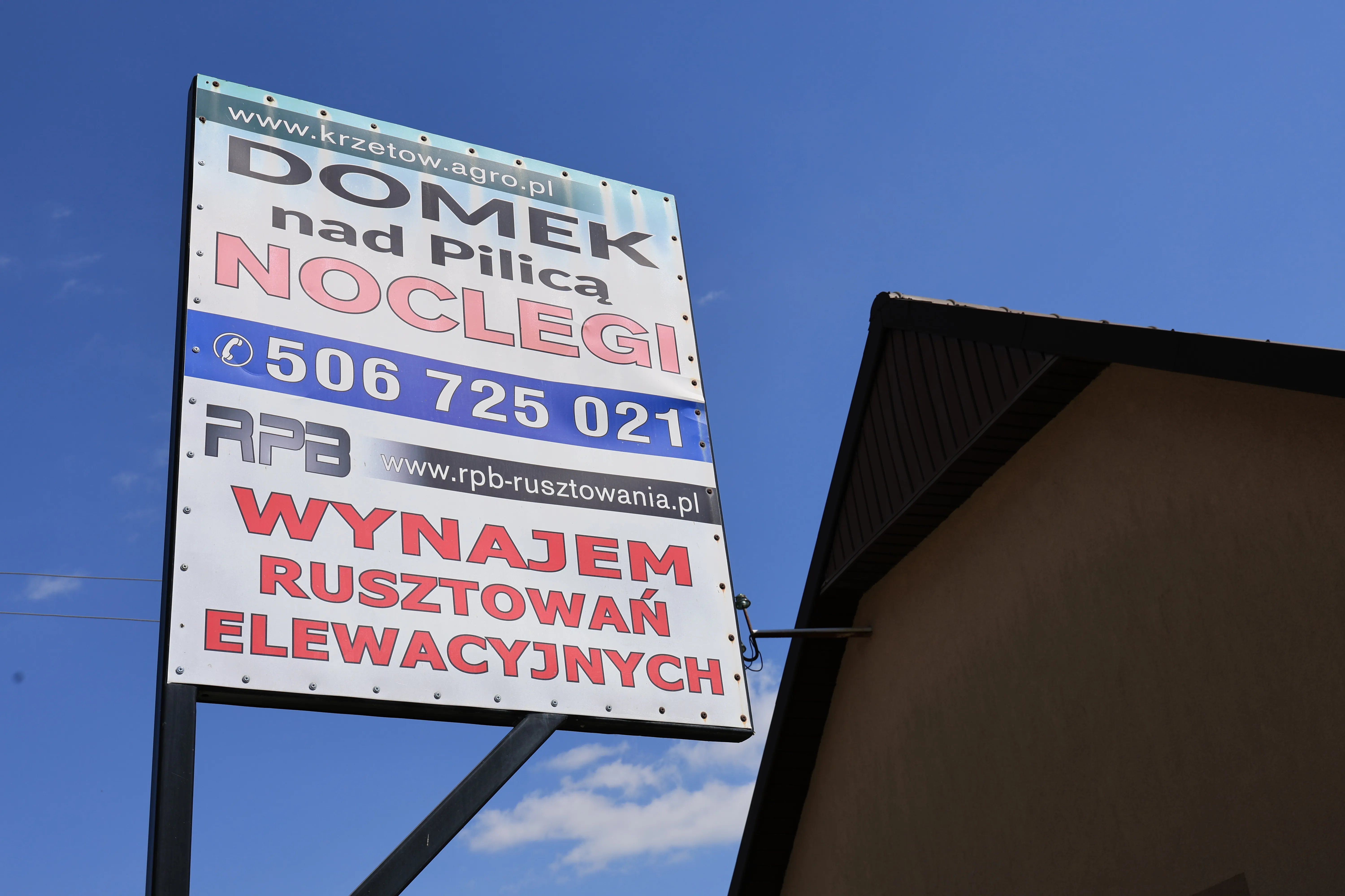 Tablica informacyjna Domek nad Pilicą w Krzętowie oferujący noclegi w spokojnej okolicy nad rzeką Pilicą.