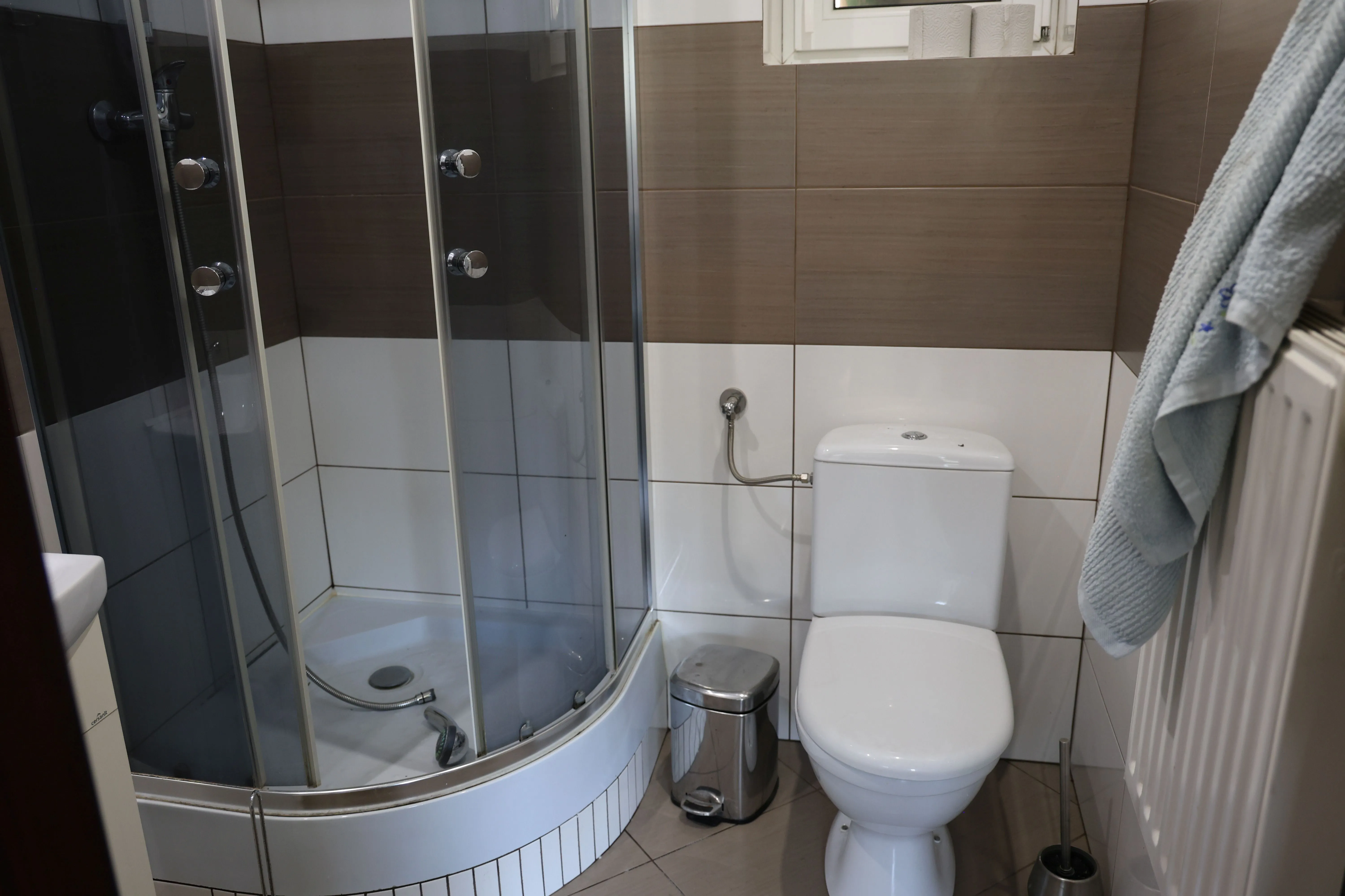 Łazienka dla gości z kabiną prysznicową, umywalką i nowoczesnym wyposażeniem sanitarnym.