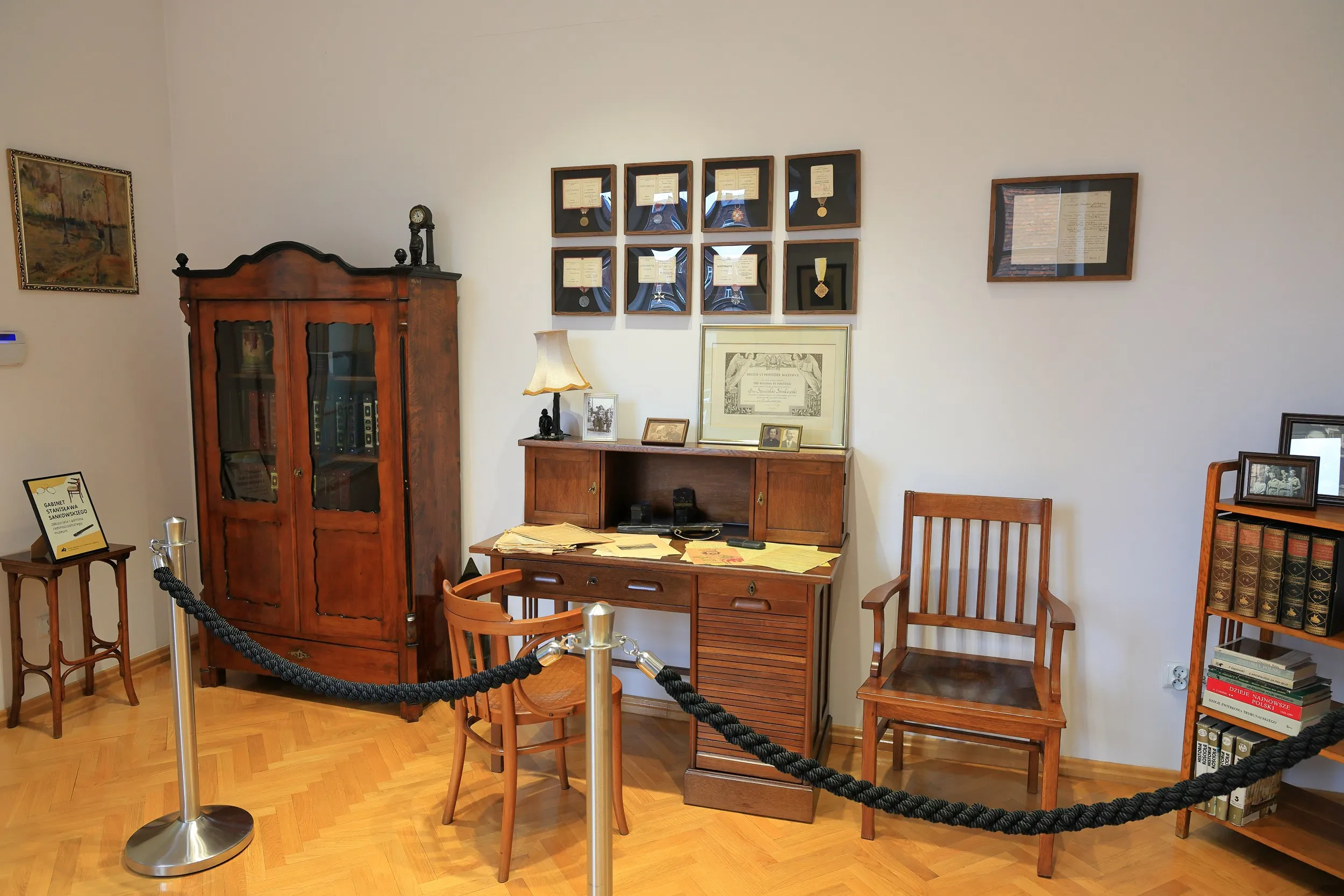 Wnętrze zabytkowego ratusza w Radomsku. Zrekonstruowany gabinet z drewnianymi meblami, dokumentami, fotografiami i pamiątkami historycznymi.