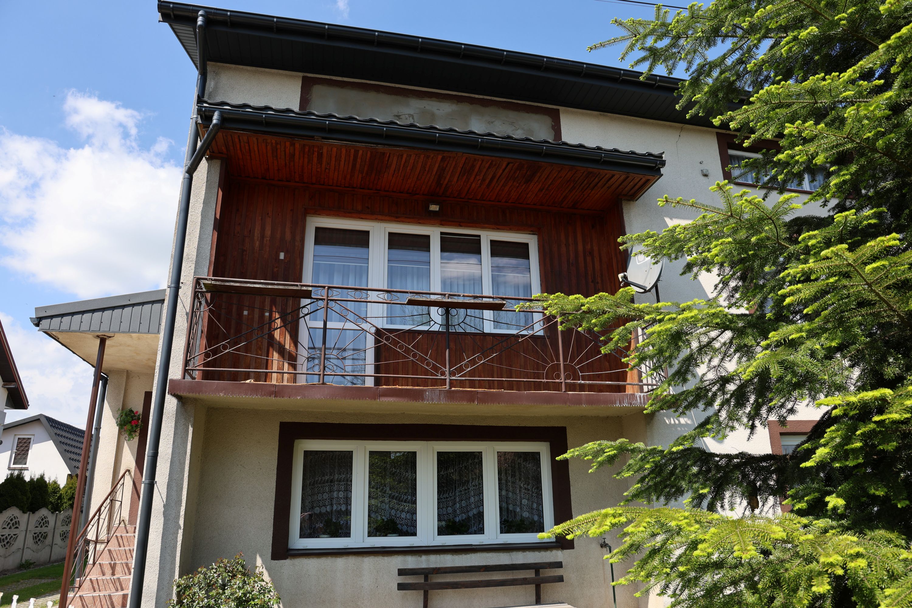Budynek Agroturystyki u Eli z balkonem oraz widokiem na zielony ogród.